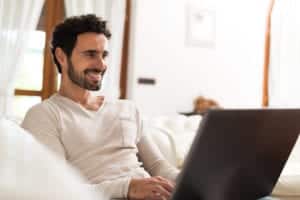 Man using a laptop while sitting on the sofa