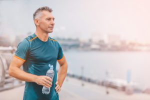 middle aged male with a drink after outdoor training.