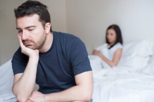 Man and woman sitting in bed feeling sad because of fertilitity problems