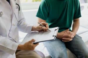 Man speaking with doctor during consultation about vasectomy and sexual health.