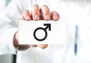 A doctor holding a card featuring the "male" symbol