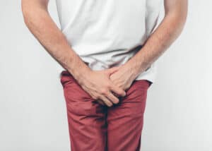 A man with urinary leakage squeezing his legs together