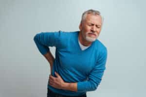 Man with a kidney stone holding his lower back